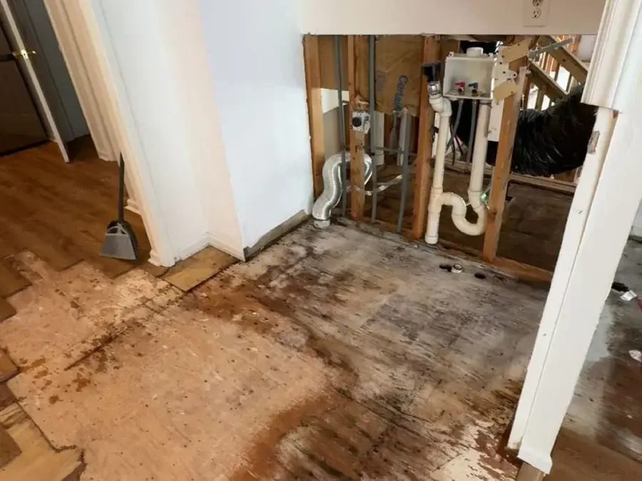 Wall opened around plumbing with wet flooring removed